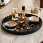 Black hammered edge marble tray with perfume bottles, jewelry bowl and gold accessories