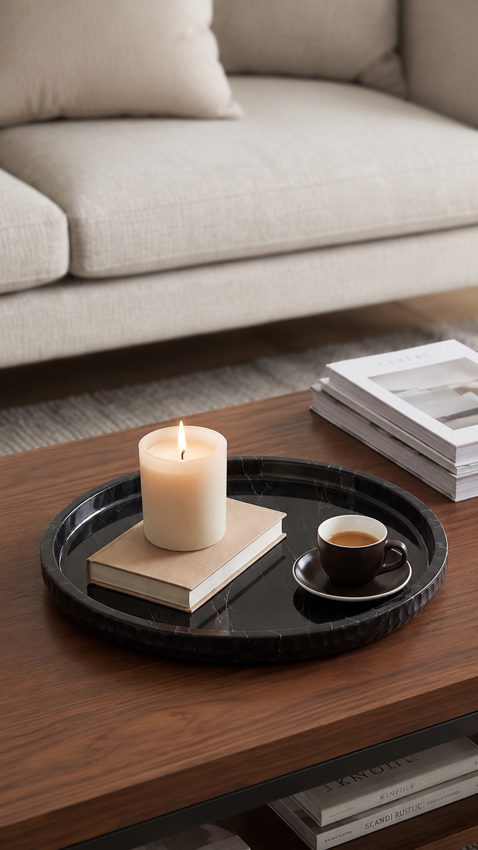Black marble tray styled with two espresso cups and a candle on dark wood table