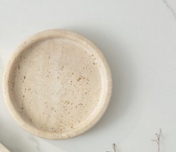 Extreme close-up of white marble tray surface showing natural stone texture and subtle veining