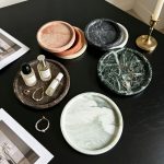 Angled perspective of dark natural marble round tray showing depth and edge craftsmanship