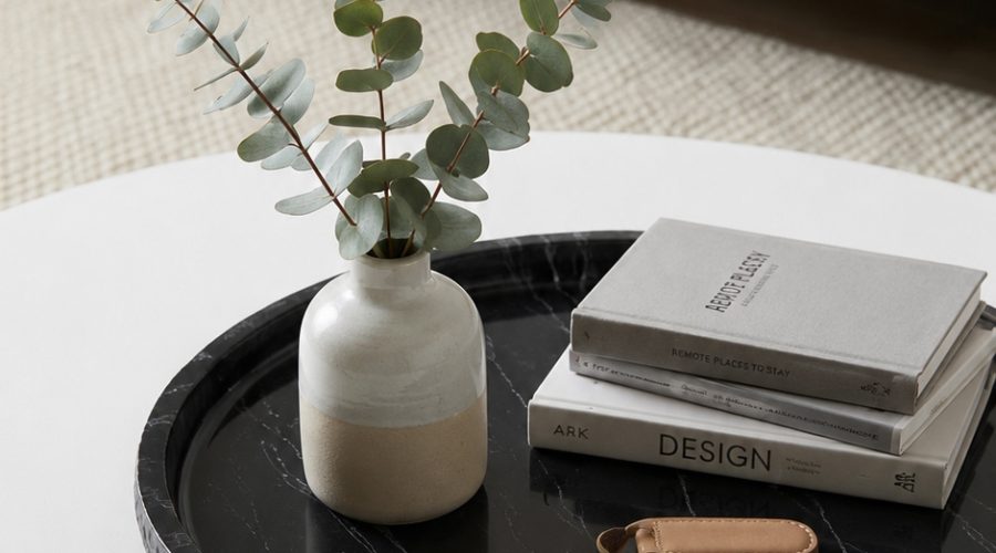 Top-down view of Nero Marquina hammered edge tray with fresh eucalyptus and decorative objects