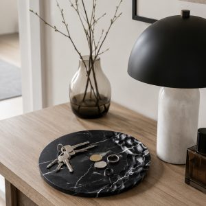 Sculpted relief Nero Marquina marble dish with organic carved surface pattern in entryway setting